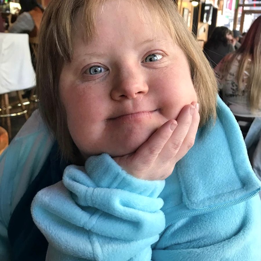 Kelsey Thomas, smiling with her chin in her hand, wrapped in her favorite blue fleece
